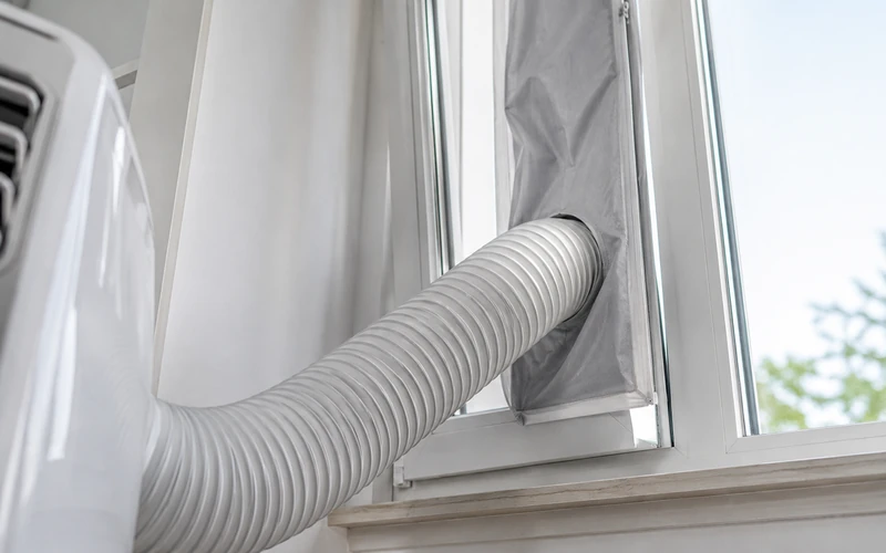 Abluftschlauch einer mobilen Klimaanlage am Fenster