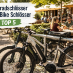Radfahrer schließen ihre Fahrräder und E-Bikes vor einem Biergarten mit verschiedenen Fahrradschlössern ab