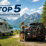 Camper laden Fahrräder vom Auto mit Fahrradträger auf einem Campingplatz vor Berglandschaft aus