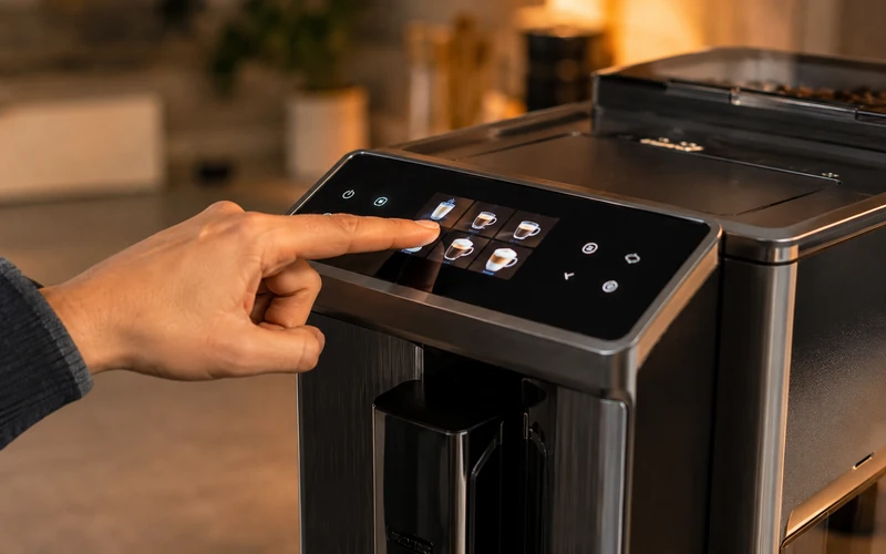 Hand tippt Einstellungen auf dem Bedienfeld eines Kaffeevollautomaten