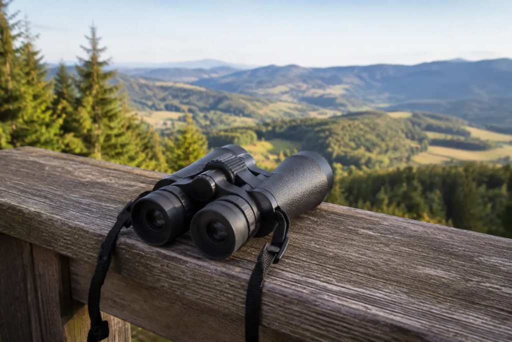 ADVENTURIDGE Zoomfernglas Aldi Nord liegt auf einem Holzgeländer an einem Aussichtspunkt mit Blick über ein bewaldetes Tal
