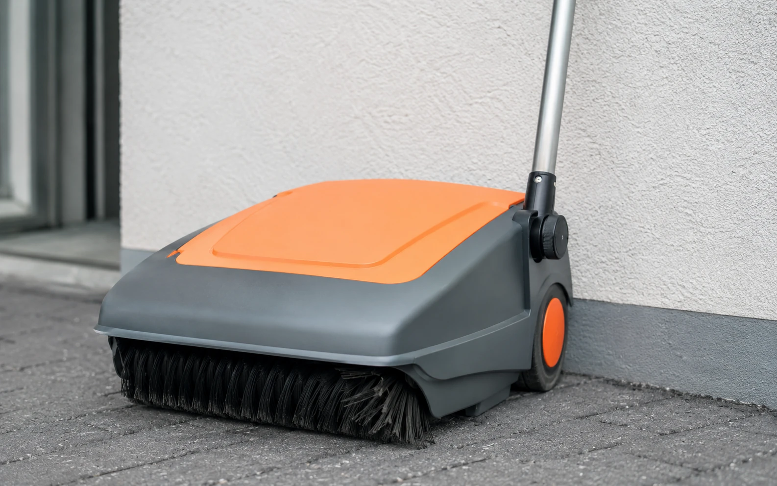 Verbogene Bürste einer Handkehrmaschine durch falsche Lagerung an der Hauswand