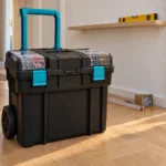 Aldi Nord Werkzeugtrolley – schwarzer Werkzeugtrolley mit türkisblauem Griff im Flur vor einem Wandregal im Aufbau